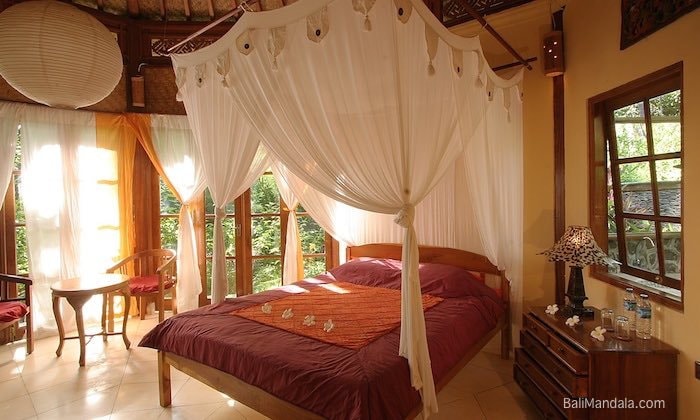 Garten-Bungalow im Bali Mandala — Himmelbett aus Holz mit Moskitonetz