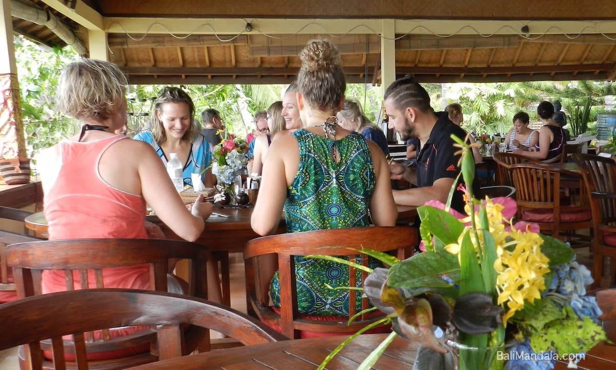 Gäste genießen eine Mahlzeit im Bali-Mandala-Restaurant, umgeben von tropischem Grün